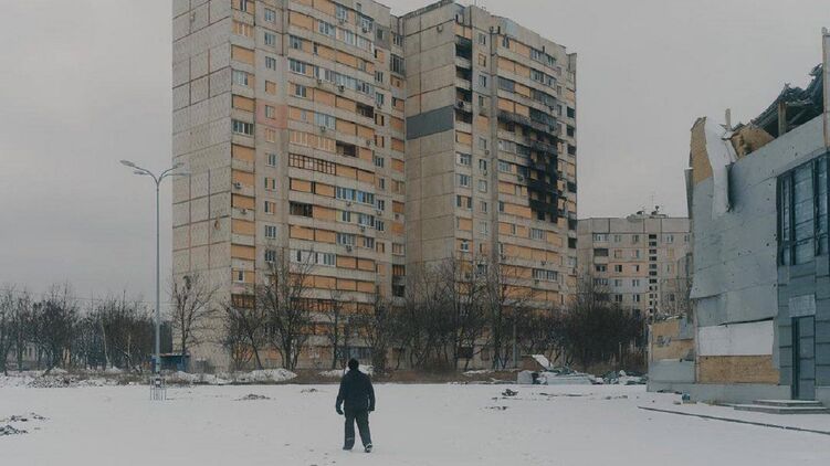 Людина на тлі багатоповерхівок, що згоріли. Ілюстративне фото: t.me/V_Zelenskiy_official